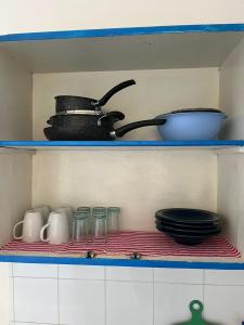 a shelf with a pot and bowls and plates at App 2 chambres rdc 200m de la plage in Mezraya