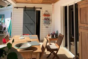 a dining room with a table and a barn door at Villa L'arbre du voyageur -Grande piscine privée vue imprenable sur l'Ocean indien in Saint-Leu