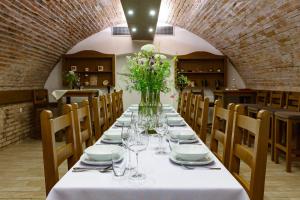 a long table with a vase of flowers on it at Terra Wylak Winery in Veľké Zálužie