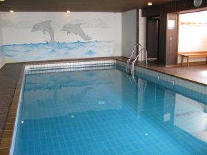 a swimming pool with a dolphin mural on the wall at Alpenappartement Berger in Steibis