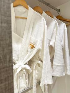 eine Reihe weißer Hemden, die auf einem Kleiderständer hängen in der Unterkunft Wendu Inn Hotel in Kota Belud