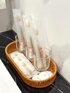 a basket with glasses on a table with white napkins at Wendu Inn Hotel in Kota Belud