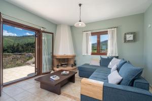 een woonkamer met een blauwe bank en een open haard bij Richmond Villa Greece in Póros