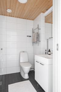 Baño blanco con aseo y lavamanos en Anna's Stylish Studio apartment near Kerava train station en Kerava