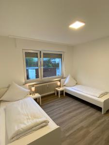 Cette chambre comprend 2 lits et 2 fenêtres. dans l'établissement CaJu-Stays Monteurwohnung - Barntrup, Blumenstr. 1b, à Barntrup