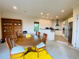 cocina y comedor con mesa de madera y sillas en ROOM IN GREAT SEA VIEW HOUSE, en Wellington