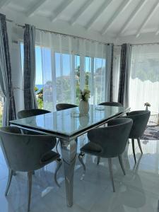 une salle à manger avec une table et des chaises en verre dans l'établissement Villa la Barraca, à Jávea