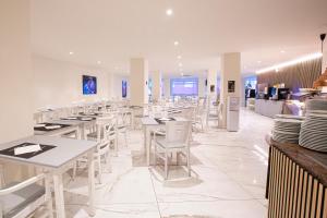 a restaurant with white tables and white chairs at FLEMING PLAYA PONIENTE in Benidorm