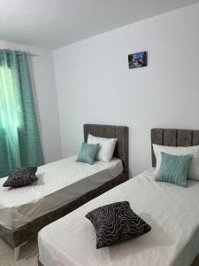two beds sitting next to each other in a room at App 2 chambres rdc 200m de la plage in Mezraya