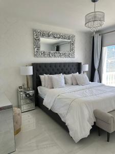 - une chambre avec un grand lit et un miroir mural dans l'établissement Villa la Barraca, à Jávea