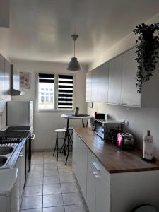 a kitchen with white cabinets and a counter top at Disneyland Family and Friends great location apart in Chessy