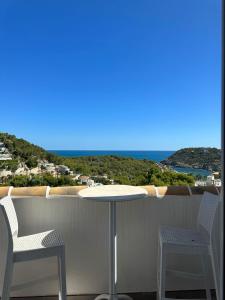 d'une table et de deux chaises sur un balcon donnant sur l'océan. dans l'établissement Villa la Barraca, à Jávea