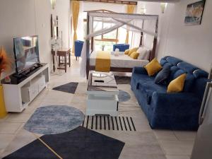 un soggiorno con un divano blu e un letto di SERENITY COVE a Ukunda