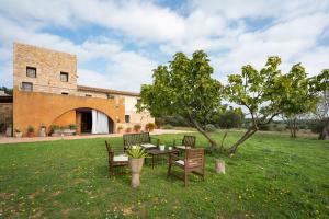 a table and chairs in a field with a building at Mas Coquells Habitación doble de 2 camas in Vilanant