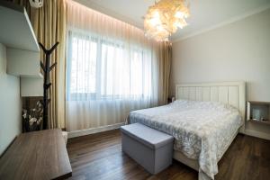 um quarto com uma cama e um lustre em Apartment Antique Theatre 2 em Stara Zagora