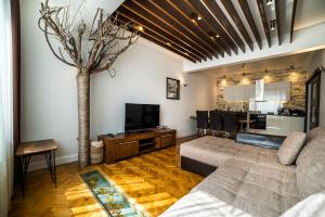 a living room with a couch and a tree at Apartment Antique Theatre 2 in Stara Zagora