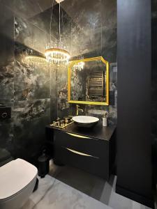 a bathroom with a sink and a toilet and a mirror at Luksusowy Apartament Joker 2 in Szklarska Poręba