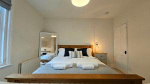 a bedroom with a large bed with two pillows at City Centre with Hot Tub - 3 Bed in Kent