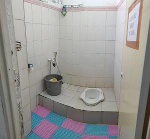 een kleine badkamer met een toilet in een stal bij Penginapan Wanita Putri Salju Hostel Semarang in Semarang