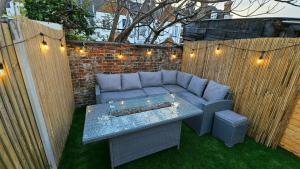 a patio with a blue couch and a table with lights at City Centre with Hot Tub - 3 Bed in Kent