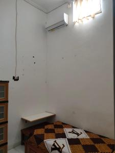 een slaapkamer met een bed met een quilt bij Penginapan Wanita Putri Salju Hostel Semarang in Semarang