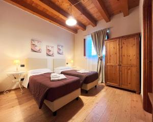 um quarto com 2 camas, uma mesa e uma janela em Agriturismo Corte Pellegrini em San Martino Buon Albergo