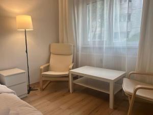 een slaapkamer met een stoel, een tafel en een raam bij Cipariu Corner in Cluj-Napoca