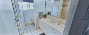 a bathroom with a sink and a mirror and a toilet at Twin Palms @ The Basin in St Georges Basin +14 photos