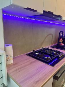 een kookplaat in een keuken met paarse verlichting bij Cipariu Corner in Cluj-Napoca