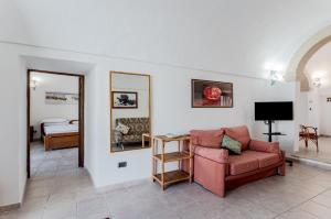 a living room with a chair and a mirror at Casetta del Manco in Corigliano dʼOtranto