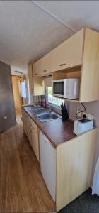 a small kitchen with a sink and a microwave at Elle in Mablethorpe