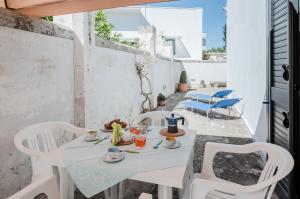 una mesa blanca y sillas en un patio en Casetta del Manco, en Corigliano d'Otranto