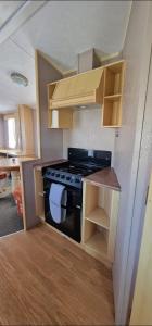 a small kitchen with a stove and some cabinets at Elle in Mablethorpe
