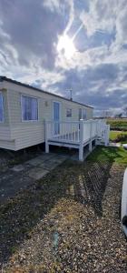 a mobile home with a porch and a white railing at Elle in Mablethorpe