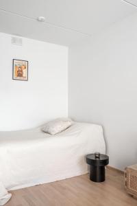 1 dormitorio con cama blanca y mesa negra en Anna's Stylish Studio apartment near Kerava train station en Kerava