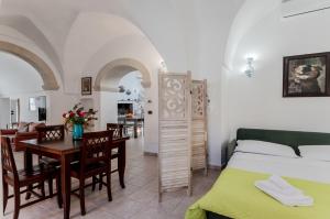 1 dormitorio con 1 cama, mesa y sillas en Casetta del Manco, en Corigliano d'Otranto