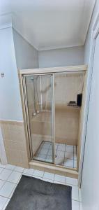 a shower with a glass door in a bathroom at Twin Palms @ The Basin in St Georges Basin