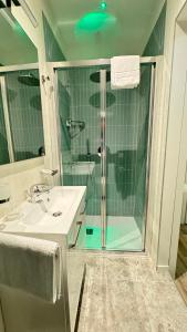 a bathroom with a glass shower and a sink at Hotel Cristina in Lido di Jesolo