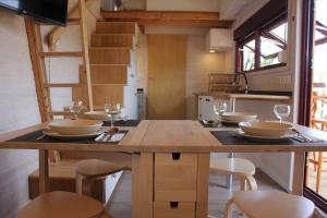 オレイロスにあるCamping Oleirosの小さな家の中に大きな木製テーブル付きのキッチン