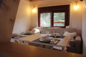 a dining room with a table with plates and wine glasses at Camping Oleiros in Oleiros