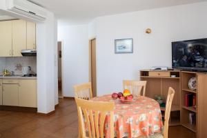 a kitchen and a table with a bowl of fruit on it at Apartments Waterfront Ivan in Podgora