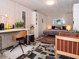 Holiday home Thyholm XXVIII في Thyholm: غرفة نوم بسرير ومكتب وكرسي