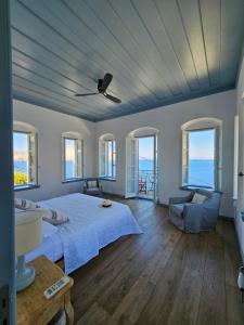 a bedroom with a bed and a couch and windows at The Anchor House in Symi