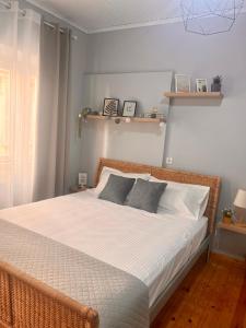 a bedroom with a bed with white sheets and gray pillows at Central Park in Corfu