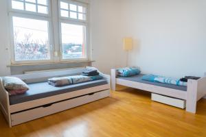 een kamer met 2 bedden en een raam bij Mainz Innenstadt 3 Zimmer Altbauwohnung in Mainz