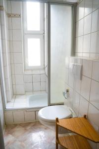 een badkamer met een toilet, een raam en een bad bij Mainz Innenstadt 3 Zimmer Altbauwohnung in Mainz
