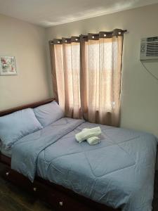 ein Bett mit zwei Handtüchern darauf in einem Schlafzimmer in der Unterkunft One Spatial Condominium, 2-Bedroom Unit #2920 in Iloilo City