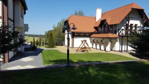 ein Haus mit Spielplatz im Hof in der Unterkunft Kryształowy Dworek in Zbychowo
