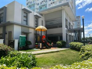 ein Gebäude mit einem Spielplatz vor einem Gebäude in der Unterkunft One Spatial Condominium, 2-Bedroom Unit #2920 in Iloilo City