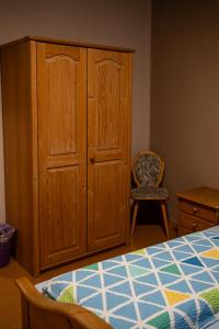 1 dormitorio con armario, cama y silla en Cafe Alte Backstubn, en Spalt